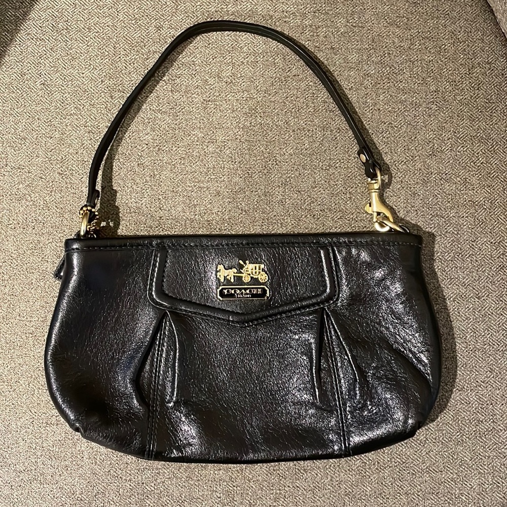 Coach strapped clutch. Black leather and red satin interior. 9 inches in length.
